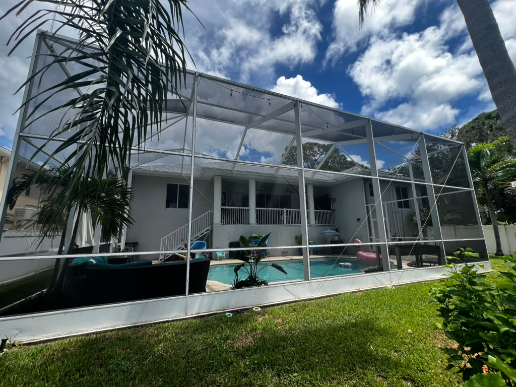 Daytime Pinellas pool cage with a clean aluminum frame and no hanging cords