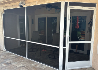 Professional technician performing a lanai screen repair on a screened porch in Oldsmar, FL.